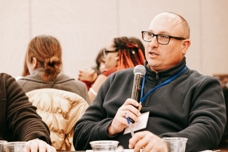 A conference attendee asking a question into a microphone