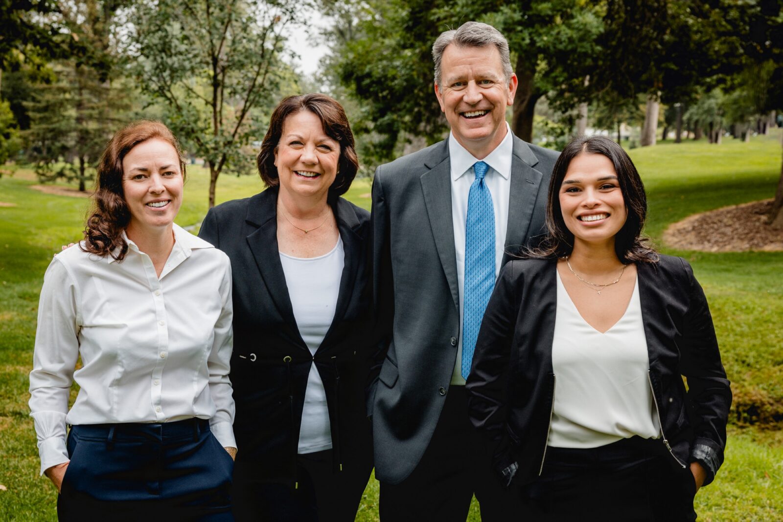 Four members of the Mollandor Owens team smiling together in a park