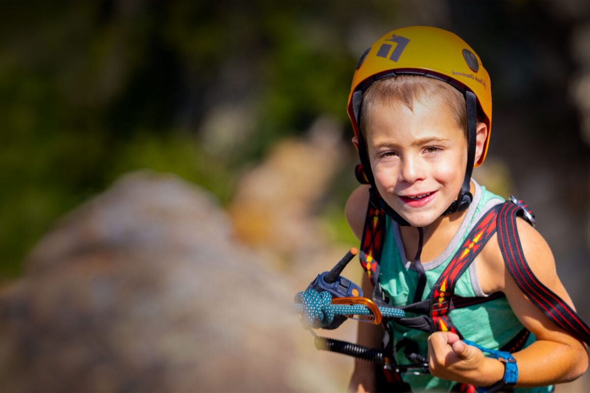 Eshai, a young climber, smiling on the rock