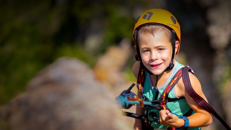 Eshai, a young climber, smiling on the rock