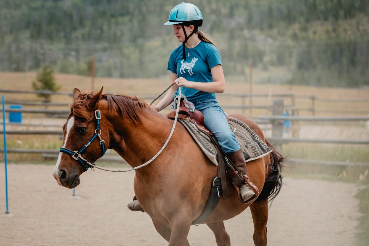 Rainah riding a horse in an NSCD arena