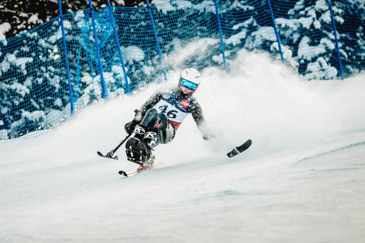 A sit-skier carving through fresh powder